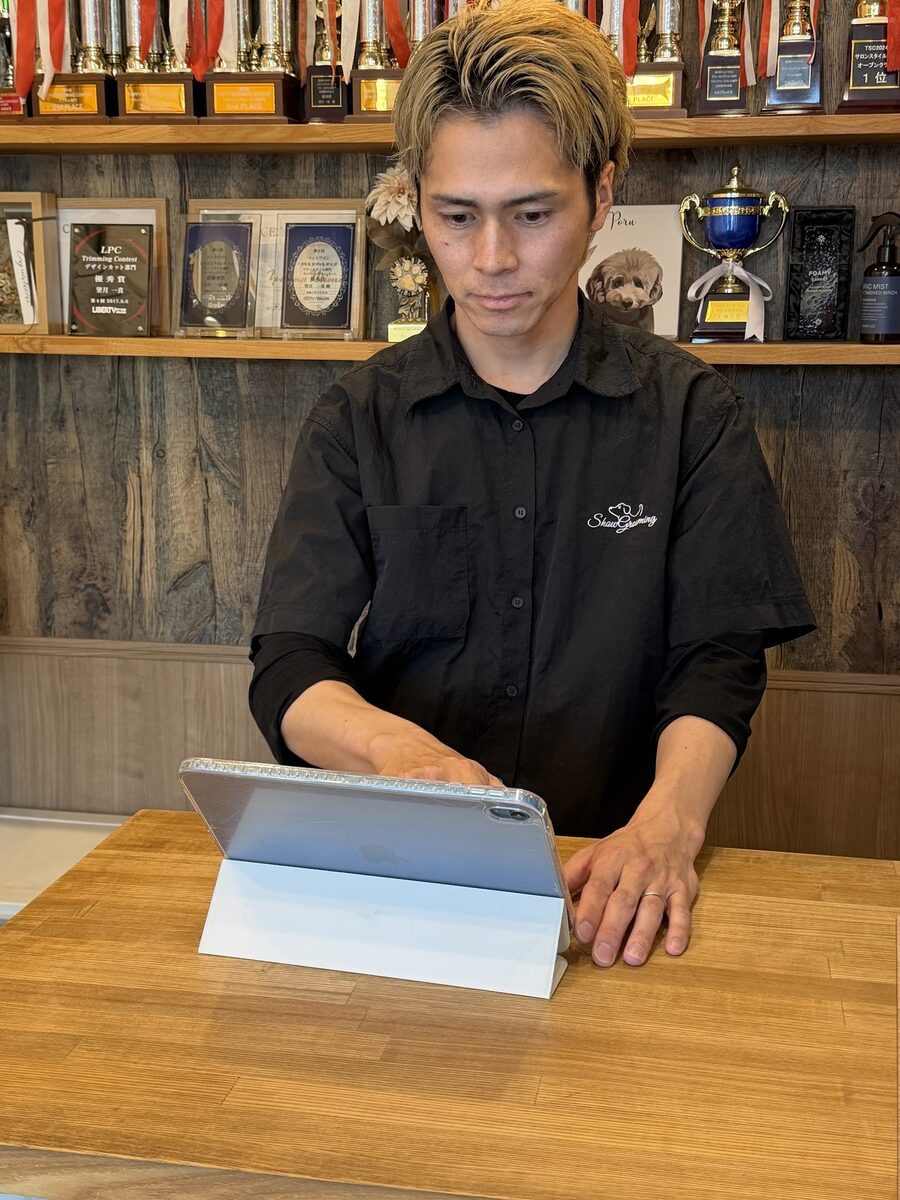 UNIPETの予約画面を確認する望月さん