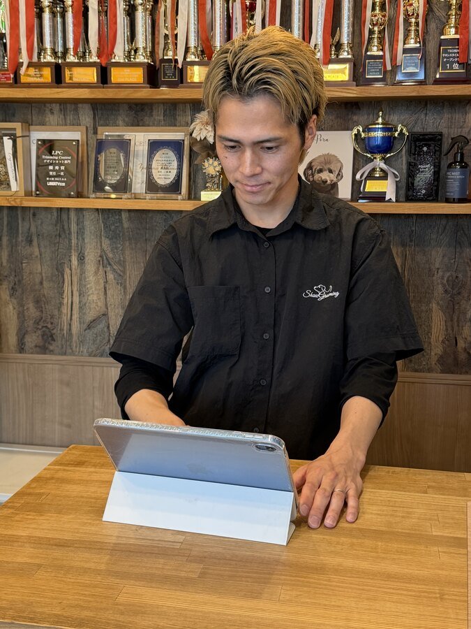 タブレットでUNIPETを操作するサロンオーナー