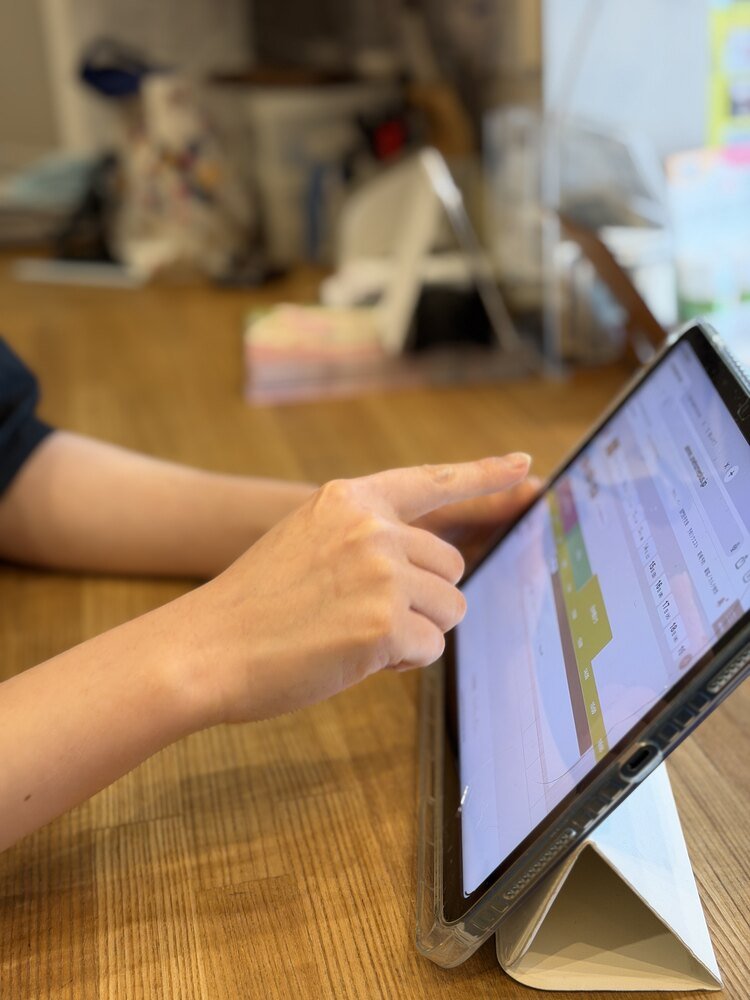 タブレットでUNIPETの予約表を確認するトリマー